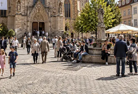 Menschen auf einem Platz vor einer Kirche