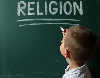 Schüler schreibt RELIGION an eine Tafel